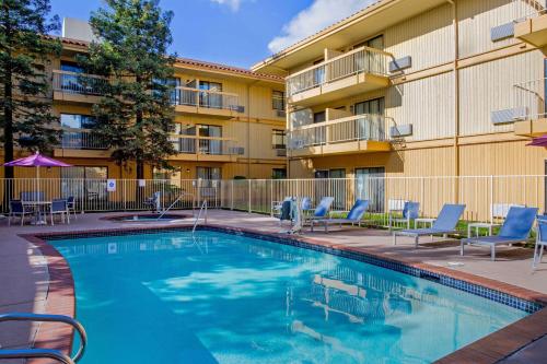 a swimming pool in front of a apartment building at La Quinta by Wyndham Oakland - Hayward in Hayward