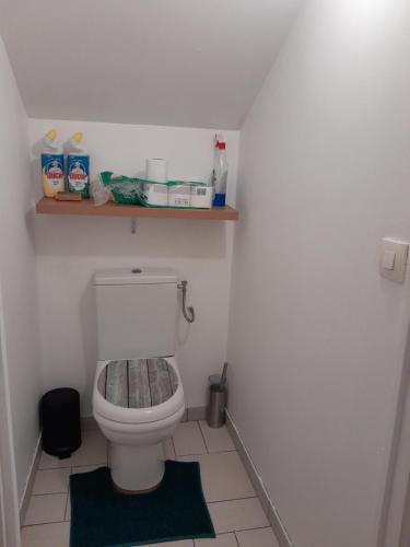 La salle de bains est pourvue de toilettes avec une étagère sur le mur. dans l'établissement Chambre Privée, à Mantes-la-Jolie