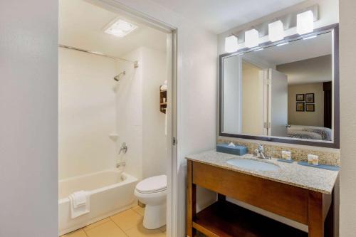 a bathroom with a sink and a toilet and a mirror at La Quinta by Wyndham Oakland - Hayward in Hayward