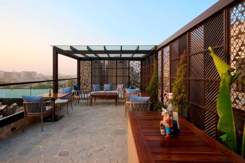 a patio with a table and chairs on a balcony at Iris Sarovar Portico in Gurgaon