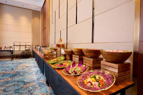 a buffet line with bowls and plates of food at Iris Sarovar Portico in Gurgaon