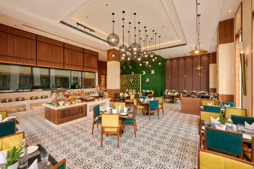 a restaurant with tables and chairs and a cafeteria at Iris Sarovar Portico in Gurgaon