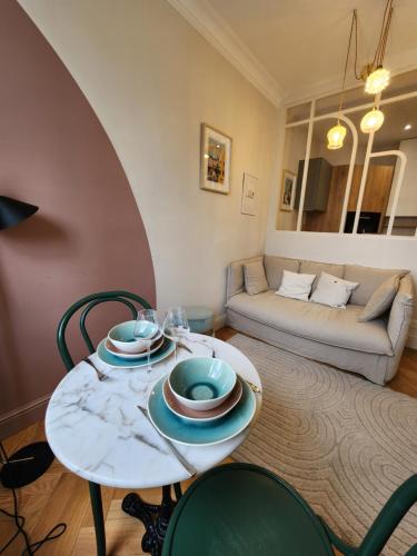 un salon avec une table, des chaises et un canapé dans l'établissement Studio with rooftop view of the Graslin Theater, à Nantes