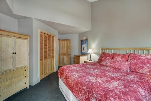 a bedroom with a large red bed and wooden cabinets at River Run Village by Keystone Resort in Keystone