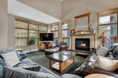 a living room with leather furniture and a fireplace at River Run Village by Keystone Resort in Keystone