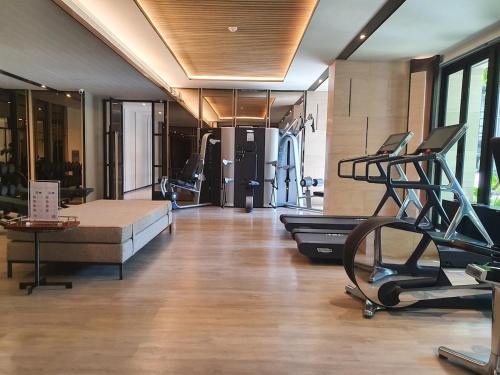 a room with a gym with a couch and exercise equipment at Luxury Japanese Onsen Reserve - Bangkok in Bangkok
