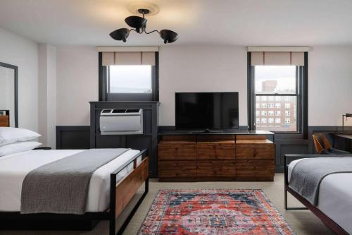 a bedroom with two beds and a flat screen tv at Hotel Morgan a Wyndham Hotel in Morgantown
