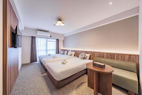 a hotel room with a large bed and a couch at Apartment Hotel 11 Shinsaibashi 5 in Osaka