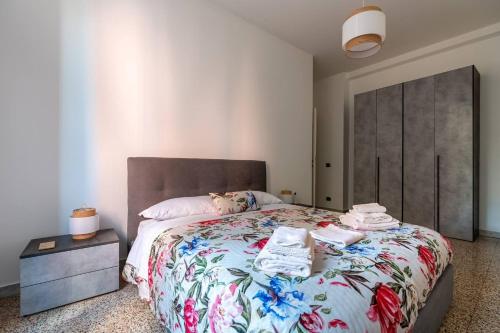 ローマにあるBrunetta Cozy ApartmentMetro Bのベッドルーム1室(花柄のベッドカバー付きの大型ベッド1台付)