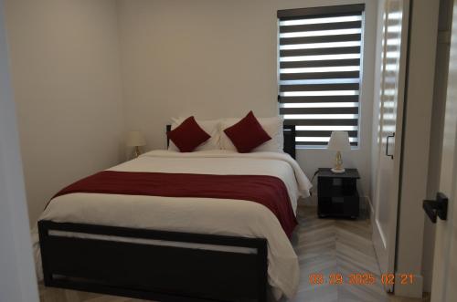 a bedroom with a large bed with red pillows at Dimond Abode Vacation Home #2 Oakland Dimond District in Oakland