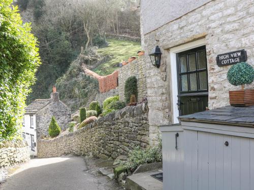 a stone building with a sign on the side of it at High View Cottage in Castleton
