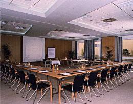 uma grande sala de conferências com uma mesa longa e cadeiras em Hotel Domicil Schönebeck em Schönebeck