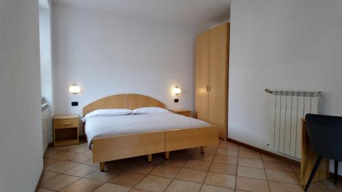 a bedroom with a bed with a wooden headboard at Residence Stella Alpina in Aprica
