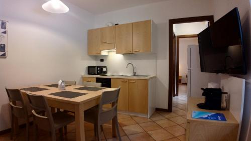 a kitchen with a wooden table and a kitchen with a sink at Residence Stella Alpina in Aprica