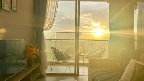 a bedroom with a view of a balcony with chairs at The Song Luxury Vung Tau - Khang Apartment 1 in Vung Tau