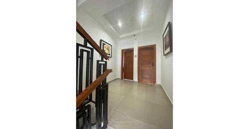 a hallway of a house with a staircase and a door at Home Xperience Luxury Apartments in Limbe