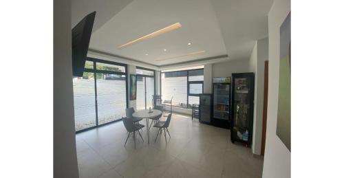 a dining room with a table and chairs and windows at Home Xperience Luxury Apartments in Limbe