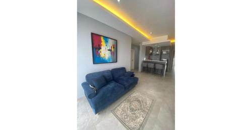 a living room with a blue couch and a table at Home Xperience Luxury Apartments in Limbe