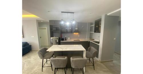 a kitchen and dining room with a table and chairs at Home Xperience Luxury Apartments in Limbe