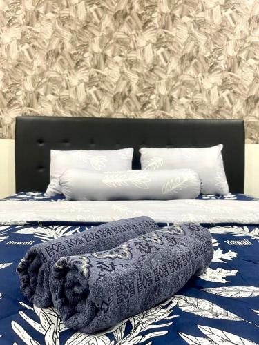 un letto con lenzuola e cuscini blu e bianchi di Villa Lotus Palagan Yogyakarta a Kejayan