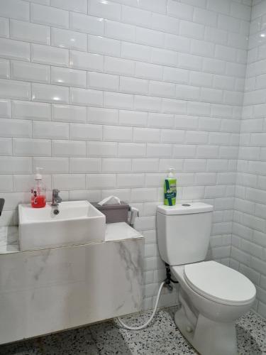un bagno bianco con un water e un lavandino di Villa Lotus Palagan Yogyakarta a Kejayan