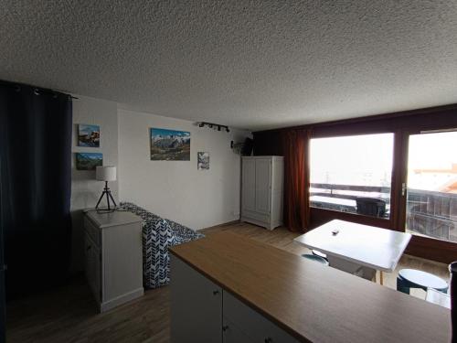 - un salon avec une grande fenêtre et un bureau dans l'établissement Résidence Chamoisiere - Superbe studio - Très belle vue - Tout confort MAE-8684, à Montgenèvre