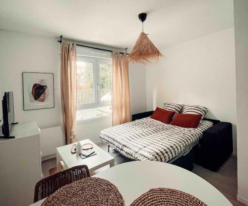 un salon avec un canapé et une fenêtre dans l'établissement Studio cosy Ile de Nantes proche tram ligne 2 et 3, à Nantes