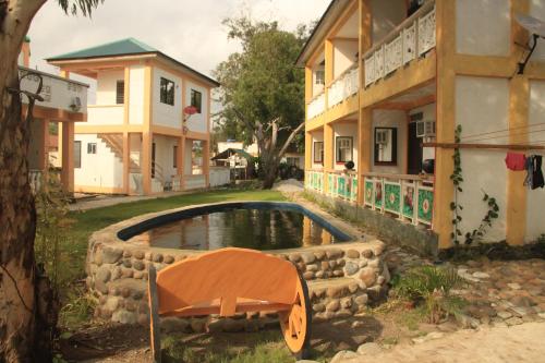 a building with a pool in front of a house at Good Guys Beach Resort in Botolan