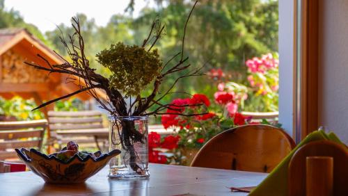 a vase with flowers in it on a table at Pension Moritz unterm Storchennest -16303 Schwedt,Schwedter Allee1 in Schwedt