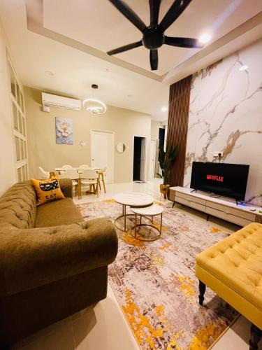 a living room with a couch and a tv at Puteri Residence in Kuala Terengganu