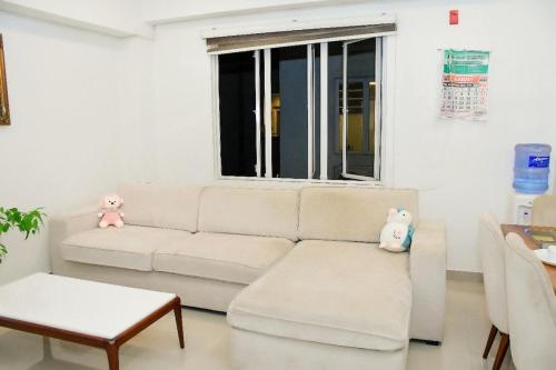 a living room with a white couch and a window at Colombo Stay apartments in Colombo