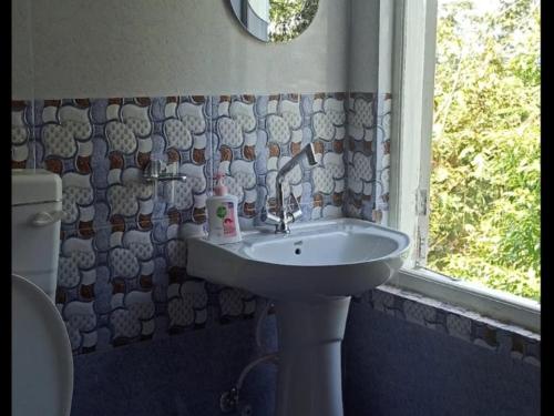 a bathroom with a sink and a window at Tinchuley Dumzon Homestay By StayApart in Takdāh