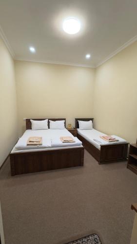 due letti in una stanza con due paraventi di Samarkand Hotel a Samarkand