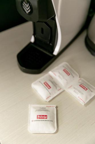 - un comptoir avec une cafetière et deux papiers dans l'établissement Chambre avec salle de bain et accès indépendant, à Nantes