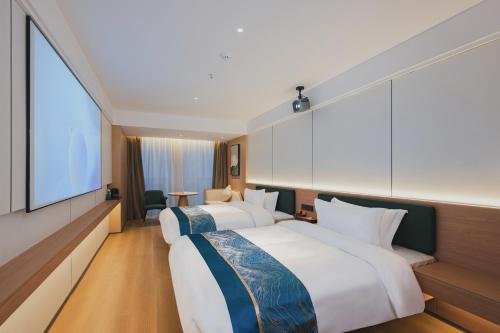 two beds in a hotel room with a large window at Ruixin Hotel Near Jiangbei Airport in Chongqing