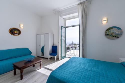 a bedroom with a blue bed and a couch at Hotel Fontana in Amalfi