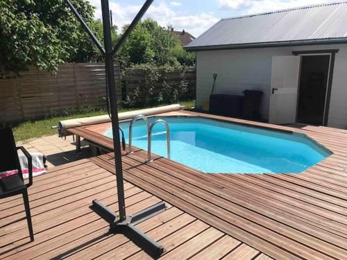 une terrasse en bois avec une piscine sur une terrasse en bois dans l'établissement Villa 1950 Détente et Découverte avec spa et piscine extérieure, à Anould