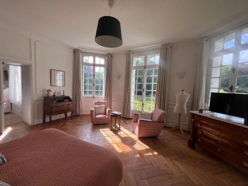 a living room with a bed and a flat screen tv at Le château de Bertreville Saint Ouen entre mer et campagne in Bertreville-Saint-Ouen