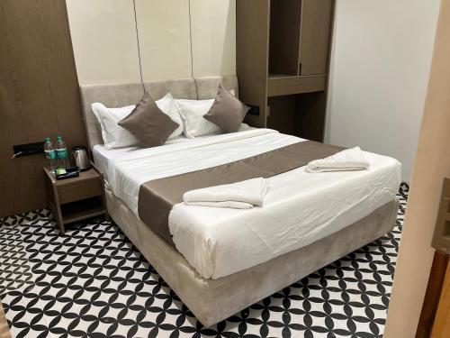 a bedroom with a large bed with a black and white floor at Hotel Prince Garden Daman in Daman