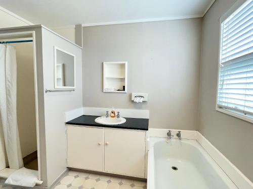 a bathroom with a sink and a bath tub at Mount Eden Motel in Auckland