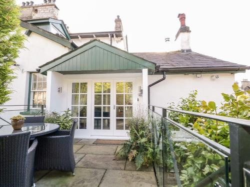 un patio di una casa con tavolo e sedie di The Bolt Hole a Kendal