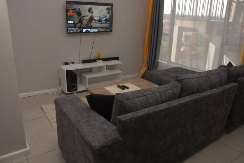 a living room with two couches and a tv at Legatus Cozy Homes in Ongata Rongai 