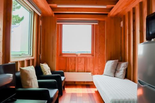 a small room with a couch and a bed and a window at kasumi terrace 霞ヶ浦 in Namegata