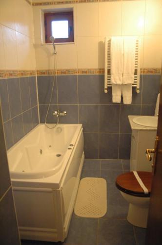 a bathroom with a tub and a toilet and a sink at Voila Inn in Constanţa