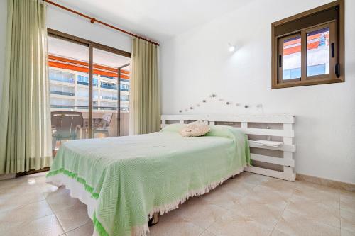 Un dormitorio con una cama y una ventana grande. en Apartamento Familiar en la Pineda, en La Pineda
