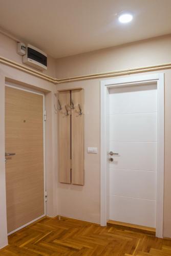 an empty room with a door and a fan at Apartman Happy day Valjevo in Valjevo