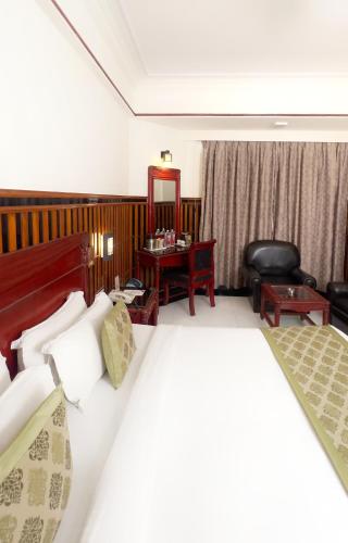 a hotel room with a bed and a chair at Hotel Mera Mann in Lucknow