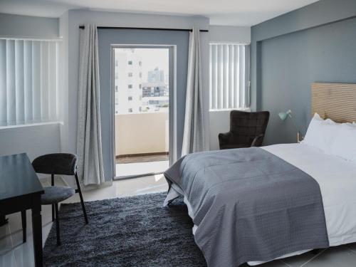 a bedroom with a bed and a desk and a window at Romilly Beachfront 92 in Strand