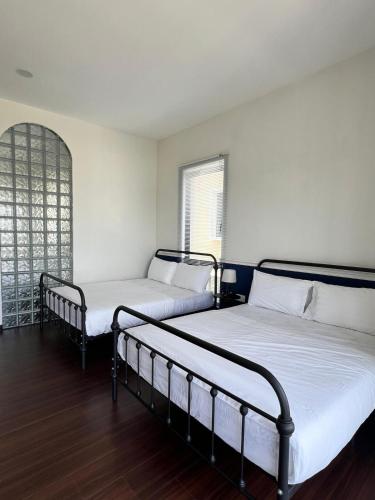 two beds in a room with wooden floors at Senai Hill 24 Homestay in Kampong Saleng