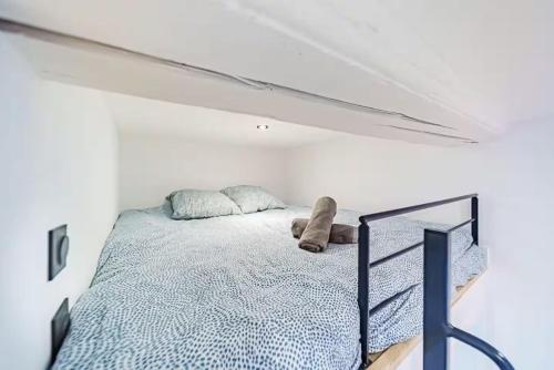 Un dormitorio con una cama en una habitación blanca. en Studio cosy avec mezzanine, bien équipé, Caluire, en Caluire-et-Cuire